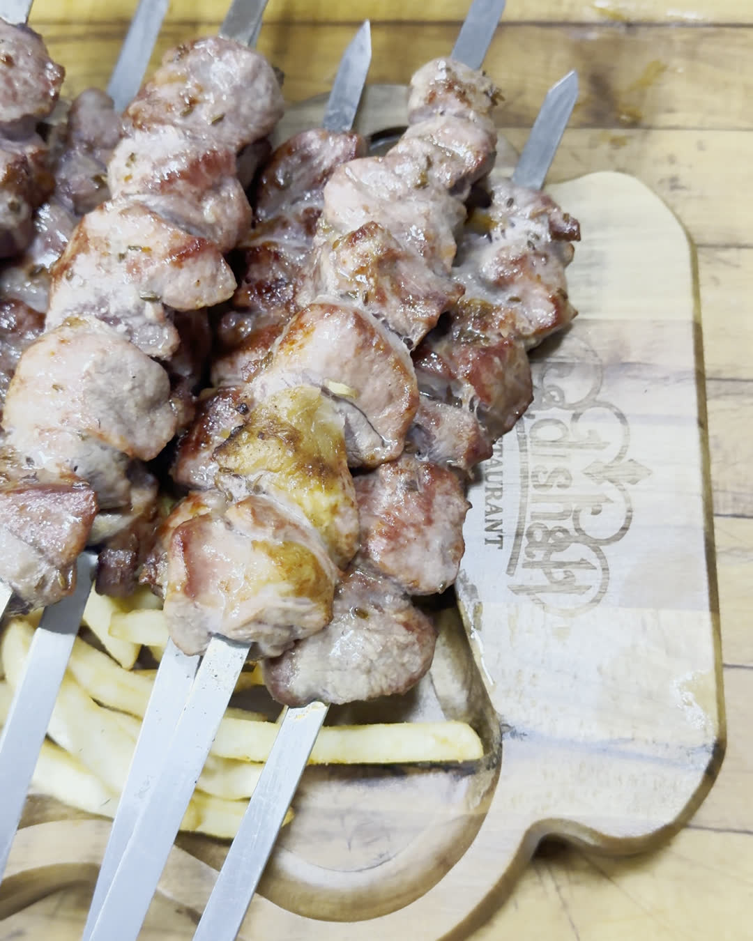 The shashlik board from above: skewers, fries and red onion